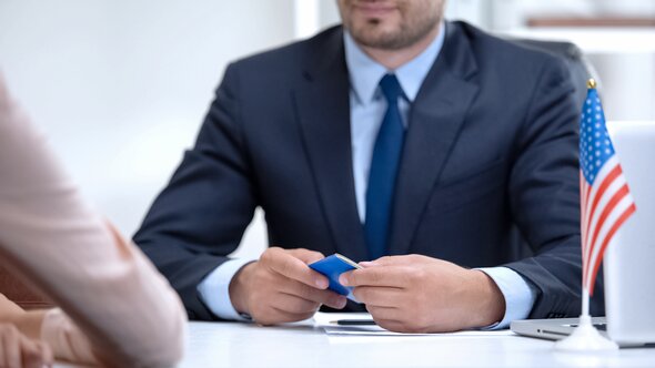 A lawyer holding a US passport during a consultation meeting.